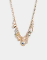 Collar corto dorado con cadena de eslabones y dijes colgantes de corazón, llave, mariposa y camafeo con flores.