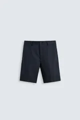 Bermuda azul marino de lino, corte regular fit, con bolsillos laterales y traseros de ojal. Cierre frontal con cremallera y botón.