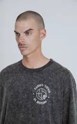 Remera negra con efecto nevado, de corte oversize y manga corta. Estampa circular en el pecho con la frase "Tarot Luxo El Mundo" y un dibujo del planeta Tierra.