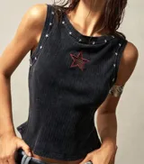 Musculosa negra de punto con cuello redondo y sisa americana. Decorada con estrellas plateadas en cuello y sisas, y una estrella roja bordada en el pecho.