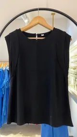 Musculosa negra sin mangas, con cuello redondo y cierre de cremallera en la espalda. Presenta un corte ligeramente holgado y detalles de costura que definen la sisa.