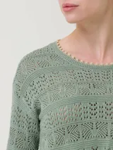 Sweater de punto calado color verde salvia, con cuello redondo y mangas largas acampanadas.