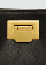 Bolso tipo bucket color marrón, con cierre metálico dorado y correa larga desmontable.