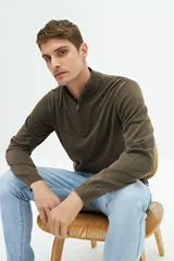 Buzo de punto color gris claro con medio cierre, cuello alto y logo bordado.