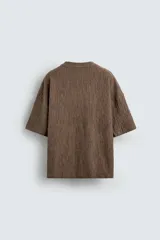 Camiseta marrón de algodón con textura irregular, corte relaxed fit, cuello redondo y manga corta.