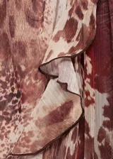 Vestido corto de gasa con estampado animal print en tonos marrones y beige, con volantes en la falda y detalle fruncido en el cuello. Diseño recto, semitransparente y de manga larga.