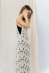 Chaleco largo tejido en punto calado color beige, de silueta recta y caída fluida. Presenta un diseño artesanal con transparencias sutiles que aportan textura y movimiento.