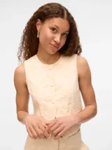 Chaleco color crema con bordado inglés, cierre frontal con botones y bolsillos tipo ojal.