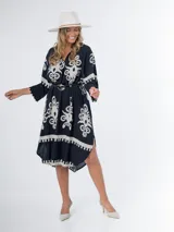 Vestido midi oversized con estampado en fondo negro, cuello tipo camisa, escote en V y tajos laterales.