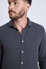 Camisa de manga larga color gris oscuro, con cuello clásico y cierre frontal con botones.