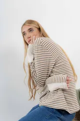 Remera de tejido de punto a rayas horizontales color naranja y blanco, de corte recto, cuello redondo y mangas largas.