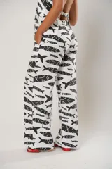 Pantalón palazzo blanco con estampado de peces negros.