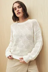 Sweater calado color blanco de punto liviano con diseño geométrico, silueta relajada y terminación en rib en cuello, puños y ruedo.