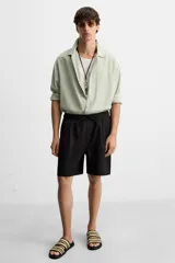 Sandalias negras con dos tiras trenzadas en color beige.