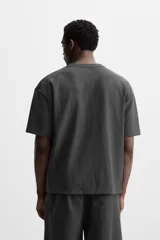 Camiseta negra de corte holgado, con cuello redondo y mangas cortas.