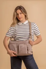 Bandolera de tafeta impermeable, liviana, con dos compartimientos principales, dos bolsillos con cierre y correa regulable con hebilla.