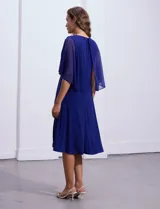 Vestido de fiesta azul marino de seda fría marca RM Richards, con escote en V cruzado, broche dorado en la cintura y mangas cortas de gasa.
