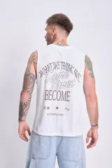 Musculosa blanca de algodón con estampado en el frente que dice 'What we think we think sometimes become' y pequeños símbolos gráficos.