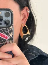 Par de aros dorados con forma geométrica irregular.