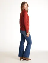 Polera tejida en hilado fino color verde oscuro, de manga larga con tajo en el puño y cuello alto.