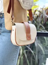 Cartera de cuero de color crudo con detalles en cuero marrón, forro de tela y bolsillo interior.
