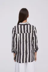 Camisa de manga larga con estampado a rayas verticales en tonos negro, blanco y verde claro.