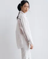 Camisa negra de lino con corte recto, cuello clásico, mangas largas y abertura en los laterales.