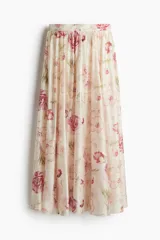 Pollera larga de tiro alto con elástico en la cintura, diseño con volumen, cintura fruncida y laterales levemente redondeados. Tiene viso corto de punto.