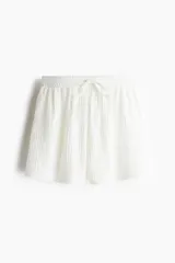 Short blanco con textura arrugada, cintura elástica y cordón ajustable.
