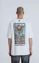 Remera color crudo de manga corta con cuello redondo y calce oversize. Estampa sublimada en la espalda con diseño de la carta del tarot 'El Sol'.