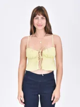 Musculosa color amarillo con breteles finos y escote con lazo.