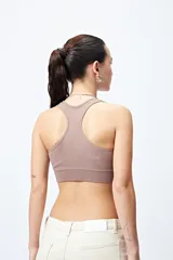 Top deportivo blanco de diseño seamless con escote en V y breteles anchos.