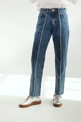 Pantalón jean mom fit de tiro alto, color azul medio con costuras blancas a la vista.