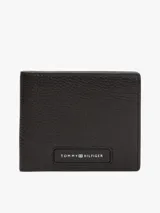 Billetera plegable Tommy Hilfiger de cuero negro con logo esmaltado en la parte delantera. Cuenta con múltiples ranuras interiores para tarjetas, compartimento para billetes, bolsillo para monedas y cinta distintiva en el interior.