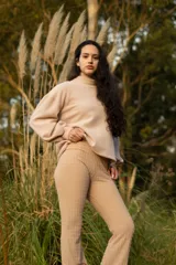 Buzo color beige de cuello alto y mangas abullonadas.
