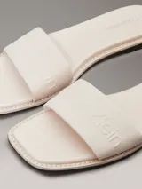 Ojotas de lona color blanco con logo grabado en las tiras, la plantilla y el talón.