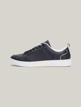 Zapatillas Tommy Hilfiger de cuero azul marino con suela blanca, cordones negros, interior blanco y detalles dorados en el talón y en el lateral.