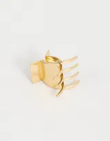 Broche para el pelo dorado con diseño de pinza y efecto metálico.