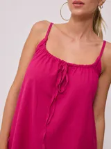 Vestido corto de algodón y lino color negro, con tirantes finos y escote recto con lazo ajustable.