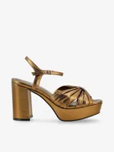 Sandalias de plataforma color dorado con detalle de nudo en el empeine y cierre de hebilla en el tobillo. El taco mide aproximadamente 7cm.