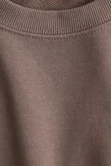 Buzo color marrón topo en tejido liviano de mezcla de algodón. Modelo con cuello redondo y hombros caídos. Remate acanalado en cuello, puños y bajo.