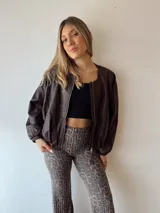 Campera marrón de cuero sintético, corte holgado, con cierre frontal y mangas largas con puños elásticos.