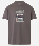 Remera gris de algodón con cuello redondo y mangas cortas. Presenta un estampado frontal de un reproductor de casete con la leyenda "To Travel".