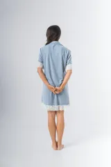 Camisa celeste con estampado a rayas verticales, de corte recto, con cuello camisero, cierre frontal con botones, mangas cortas con detalle de puntilla y ruedo con puntilla.