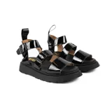 Sandalias negras charoladas con plataforma, tiras anchas y hebilla al tobillo.