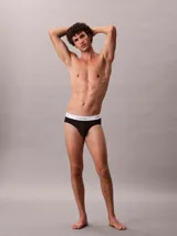 Pack de tres slips negros de algodón con cintura elástica blanca con el logo de Calvin Klein.
