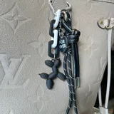 Charm para cartera o llavero con dije de perro inflable negro, sogas blancas y negras y mosquetón plateado.