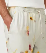 Bermuda boardshort color beige con estampado floral en tonos naranja y rosa.