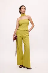 Pantalón recto color amarillo con rayas verticales blancas.