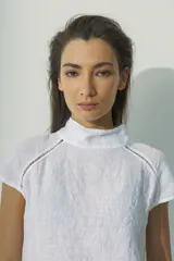 Blusa negra de lino con cuello alto y mangas cortas con detalle de calado en los hombros.